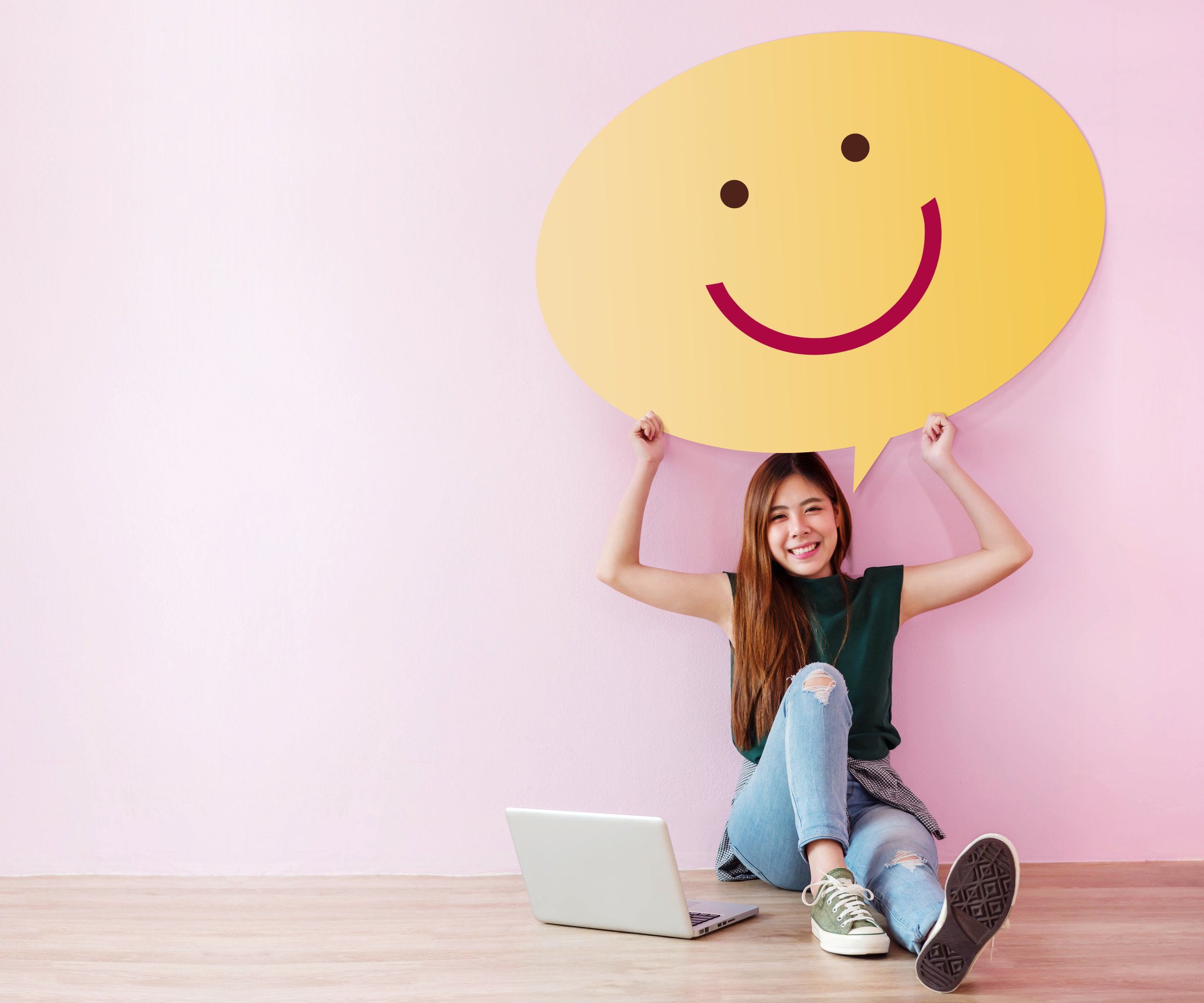 Happy Customer Concept. Review and Feedback her Experience for Satisfaction Survey Online. Young Female in Cheerful Posture, Raise up Speech Bubble with Smiley Face. Sit on the Floor with Laptop